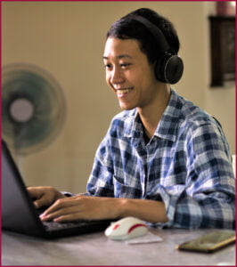 Happy teen engages with others through his online courses at Athena's Homeschool Academy.